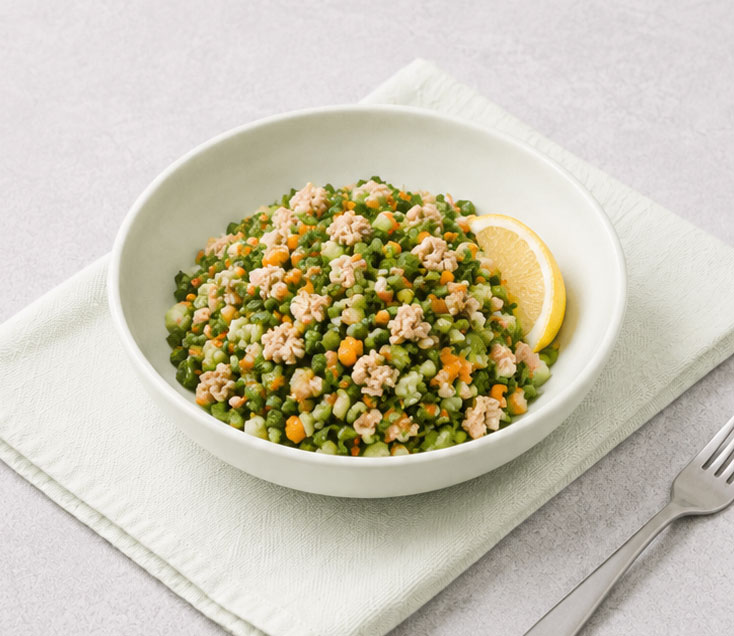 Bowl of grain salad with lemon wedge