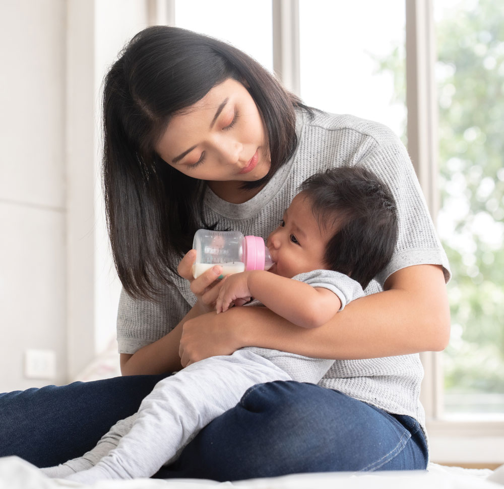 Mother bottle feeding infant baby