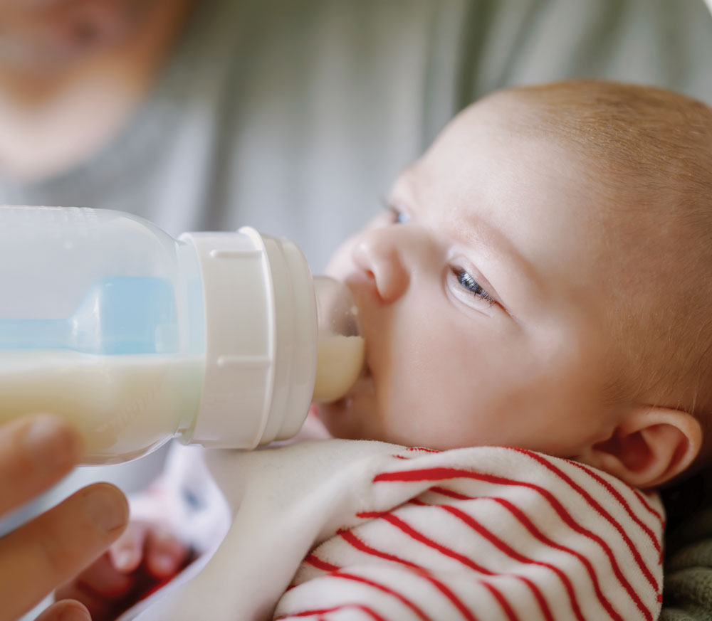 Mother feeding toddler with bottle