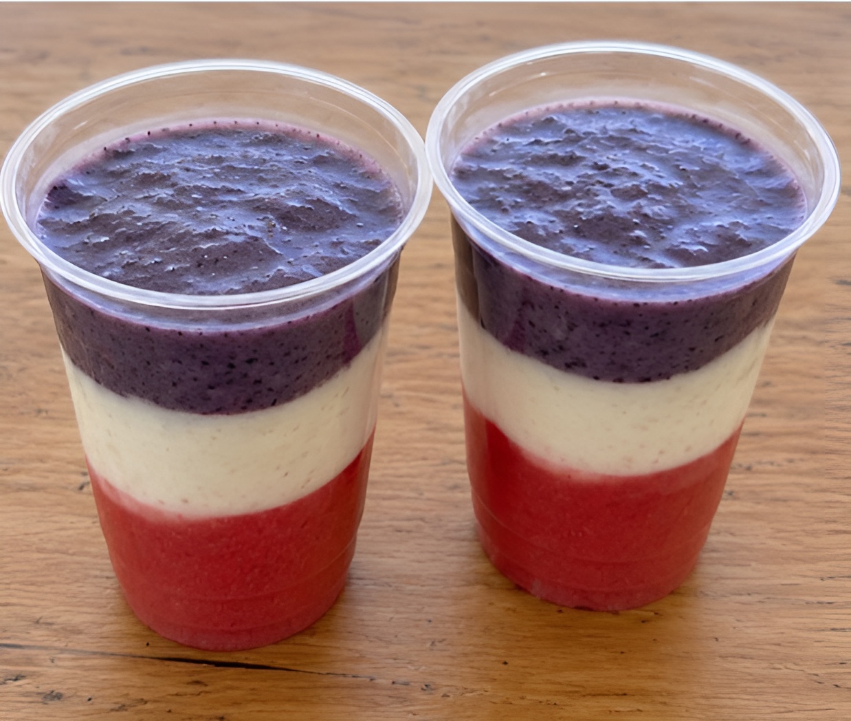 Two layered smoothies in clear plastic cups