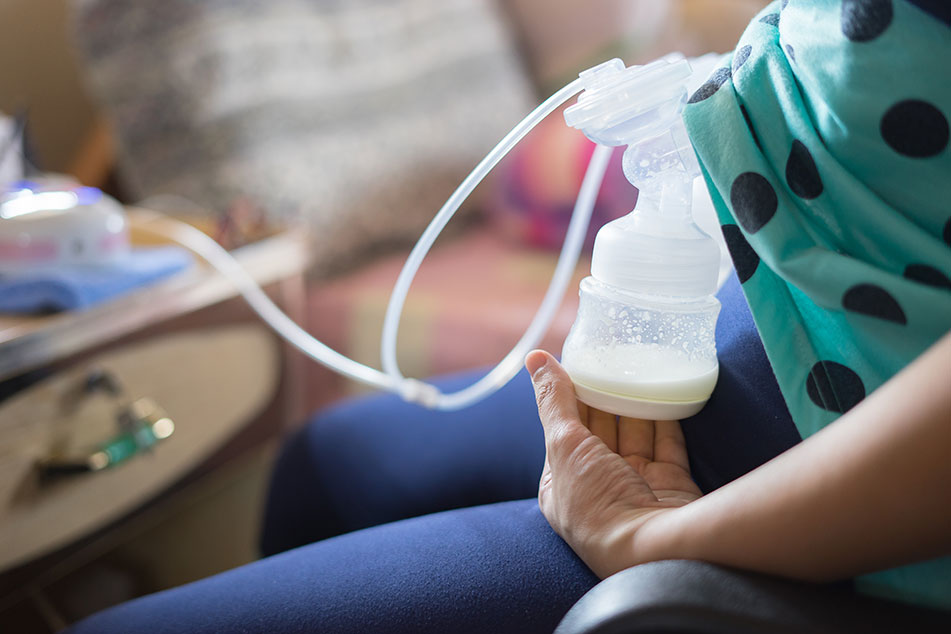 Person using a breast pump, collecting milk.