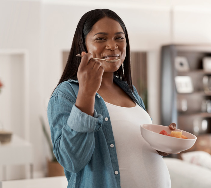 Pregnant woman enjoying a bowl of fresh fruit