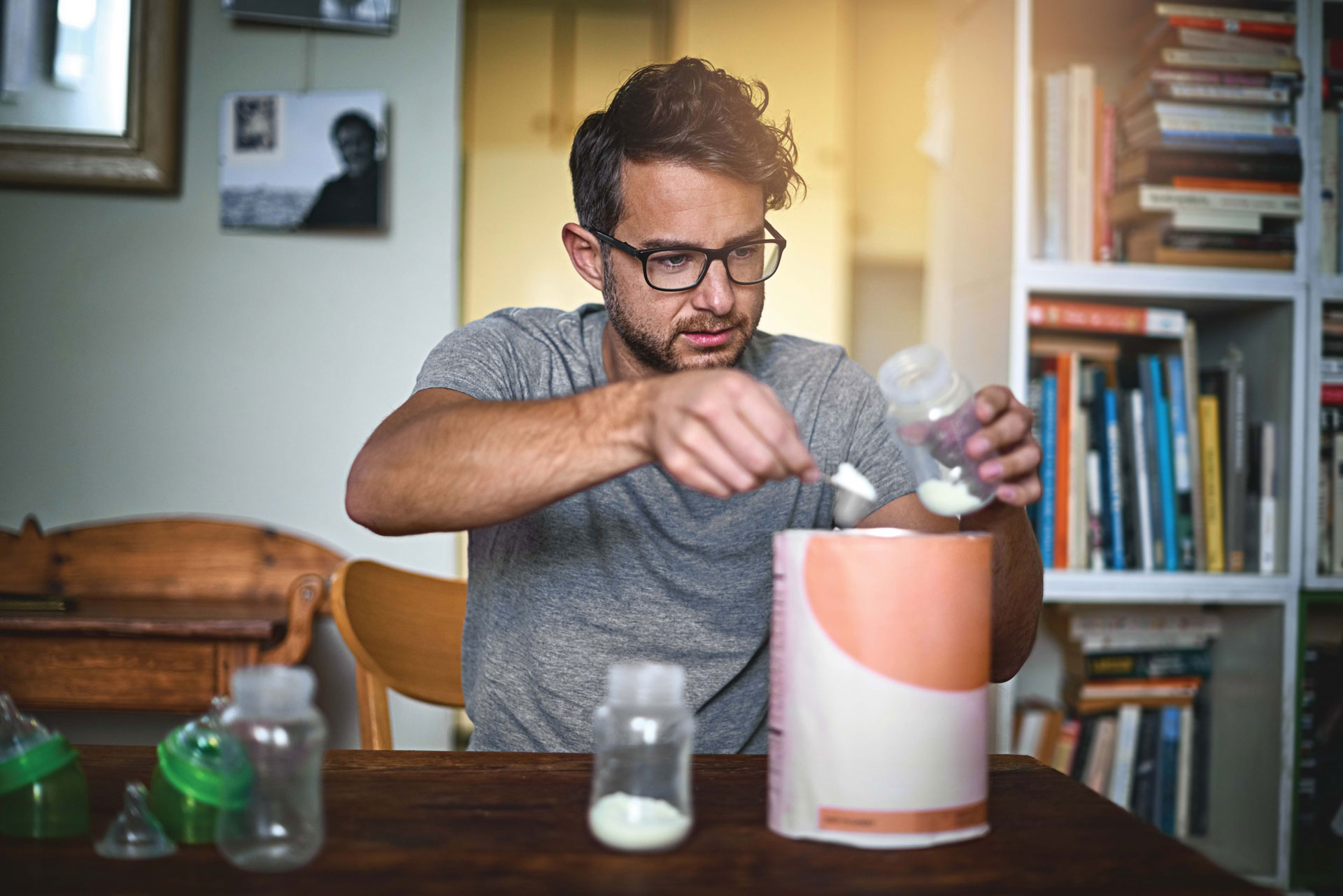 Man preparing baby formula with focused expression