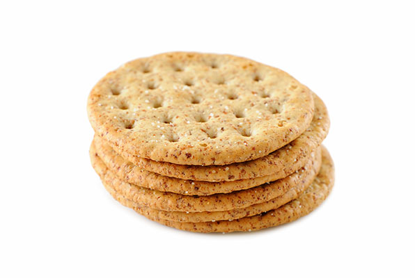 Stack of whole grain crackers on white background