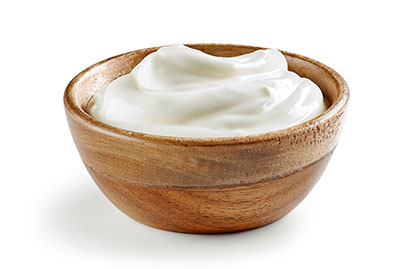 Wooden bowl filled with creamy yogurt