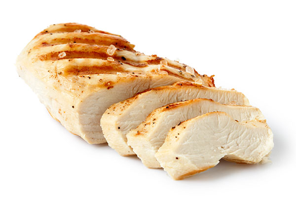 Sliced grilled chicken breast on white background