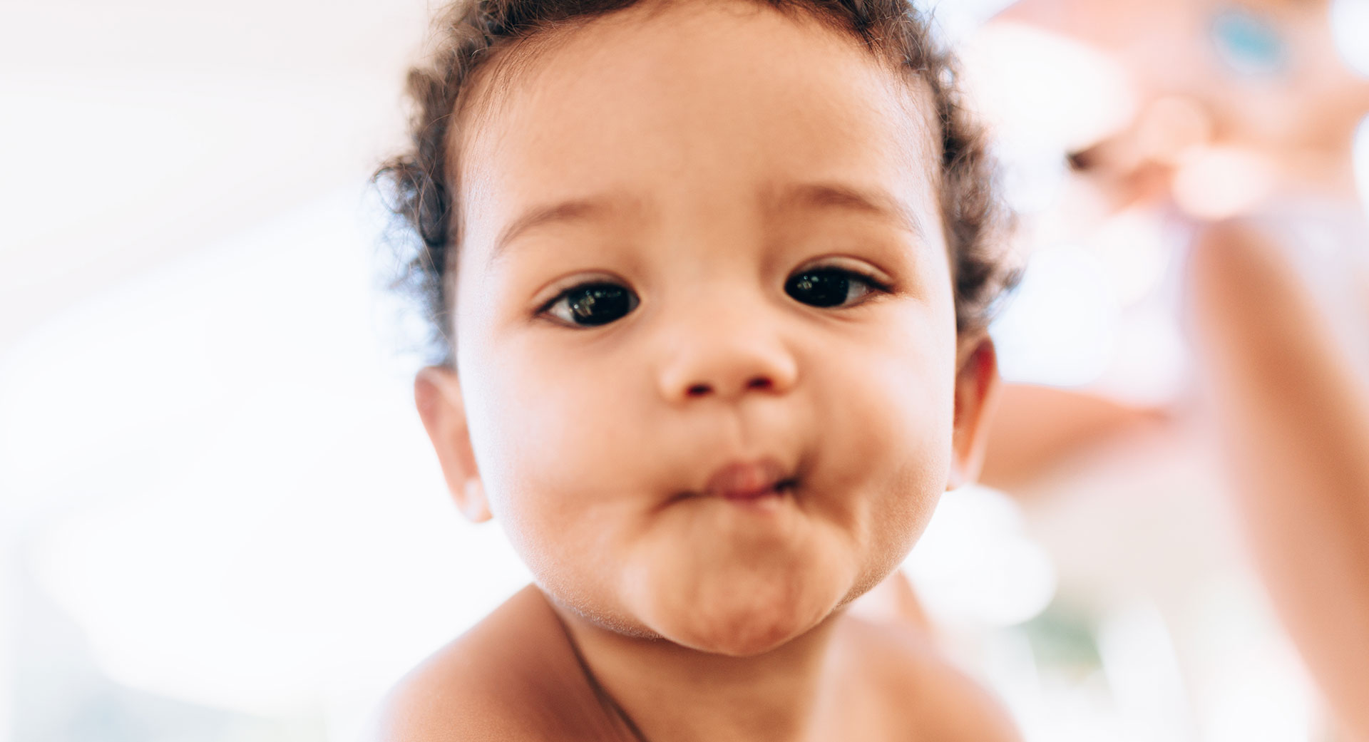 Child making a playful face, lips pursed.
